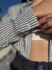 Close-up of a person wearing a striped shirt focusing on shirt cuff details.