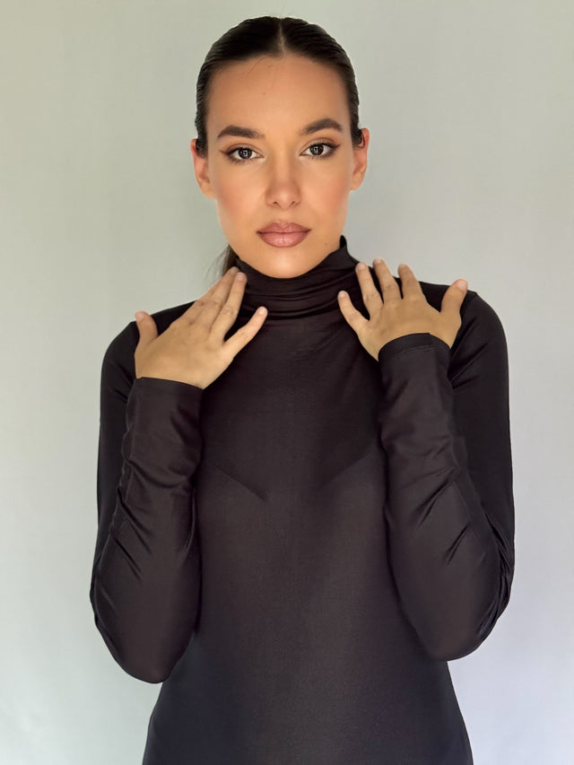 Woman wearing a black turtleneck and long sleeves dress against a plain background for anniversaries, Christmas and weddings