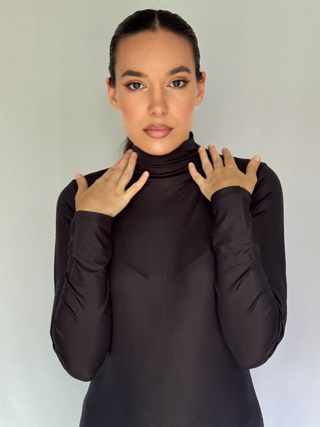 Woman wearing a black turtleneck and long sleeves dress against a plain background for anniversaries, Christmas and weddings