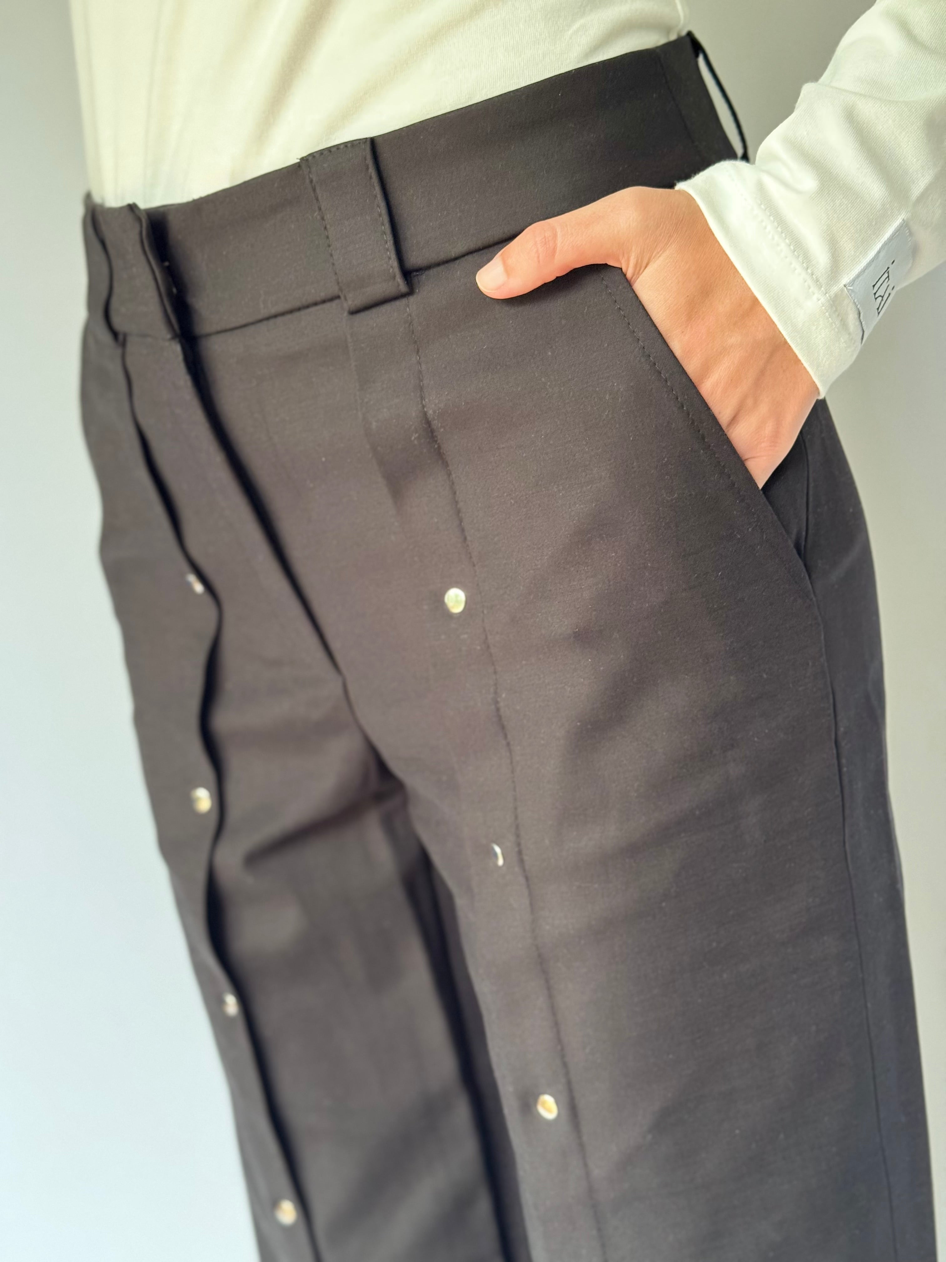 Side view of black dress pants close up view with a white shirt 